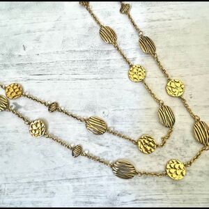 Gold tone long disc necklace